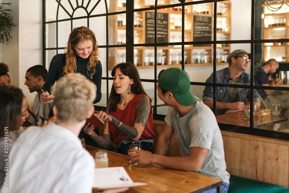 Diverse group of friends ordering food in a trendy bistro Diverse group of friends ordering food in a trendy bistro