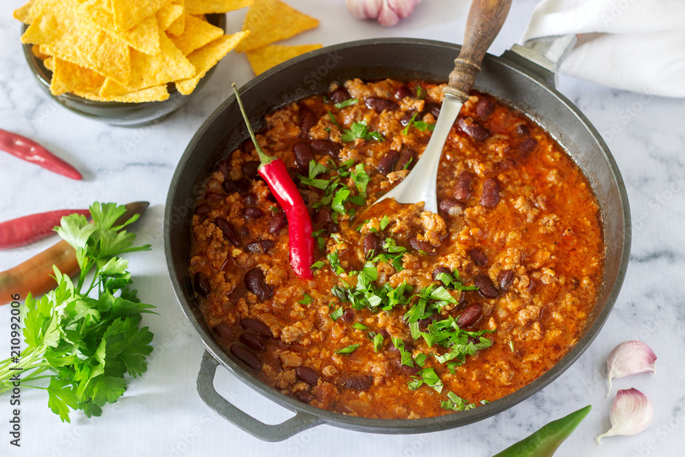 Mexican and American food Chili con carne served with nachos, pepper and herbs. Mexican and American food Chili con carne served with nachos, pepper and herbs.