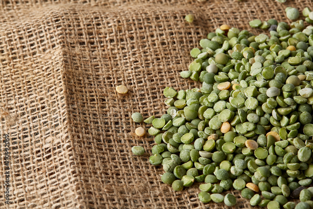 Pile of green peas on burlap tablecloth, close-up, top view, selective focus. Pile of green peas on burlap tablecloth, close-up, top view, selective focus.