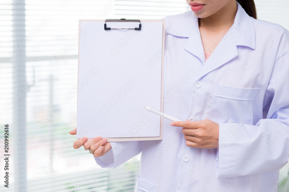 Female asian young doctor holding folder in hospital corridor Female asian young doctor holding folder in hospital corridor