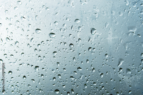 Textured background of window panes with a cloudy background. Natural pattern from a drop of rain on a cloudy background.