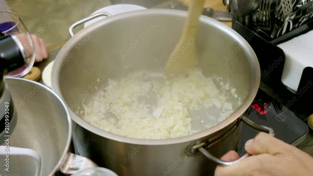 The man stewing in the pan chopped onion at cooking master class. 4K The man stewing in the pan chopped onion at cooking master class. 4K