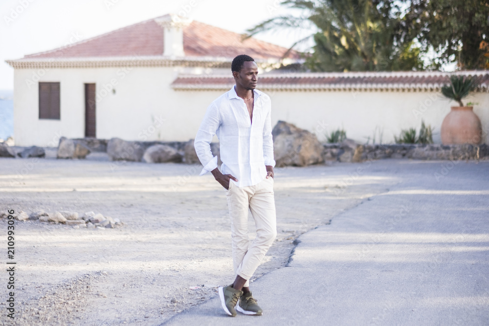 beautiful model man black african race standing on the road looking at his side. casual elegant clothes and modern guy lifestyle