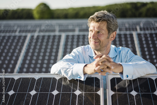 Mature man standing in solar plant photo