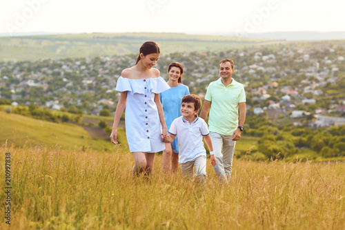 Happy family is having fun around the field at sunset. Family in nature.