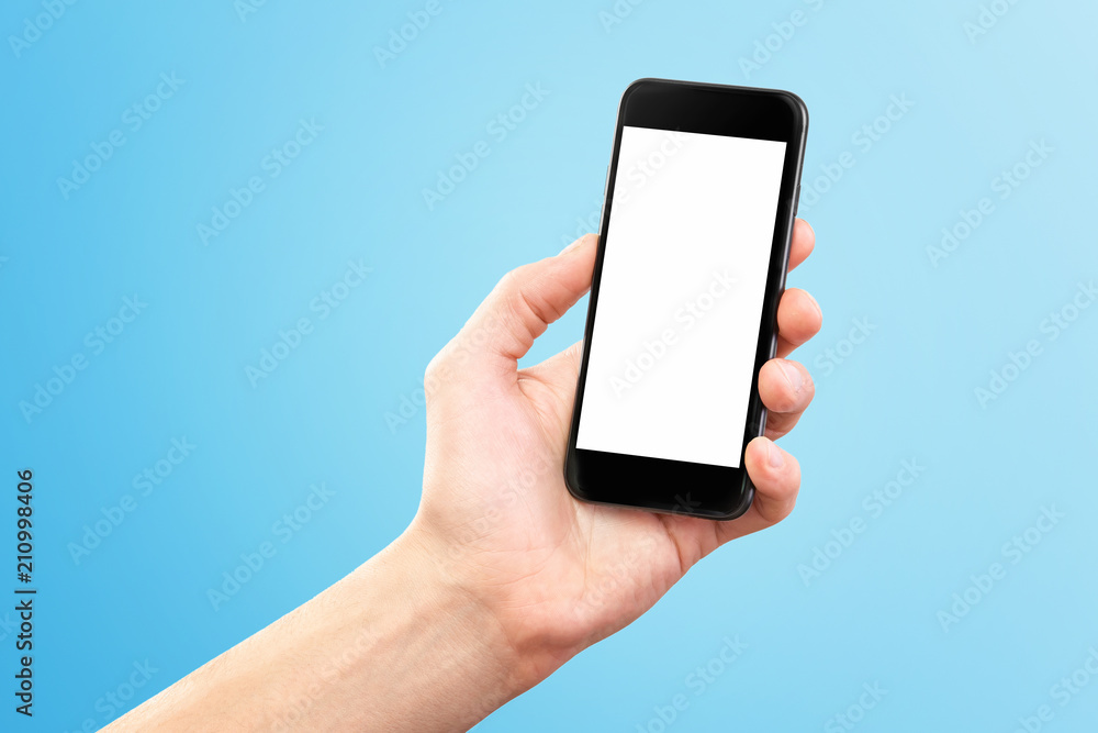 Mockup of male hand holding black cellphone isolated at blue background.