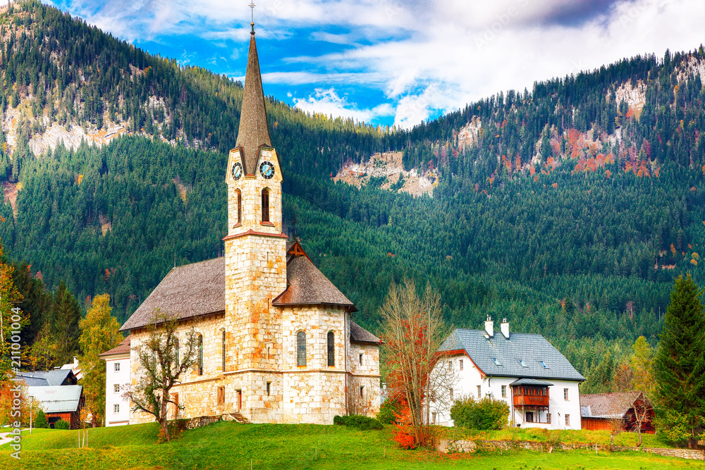 Fototapeta premium Mountains over Gosau village with Catholic Church under Sunlight.
