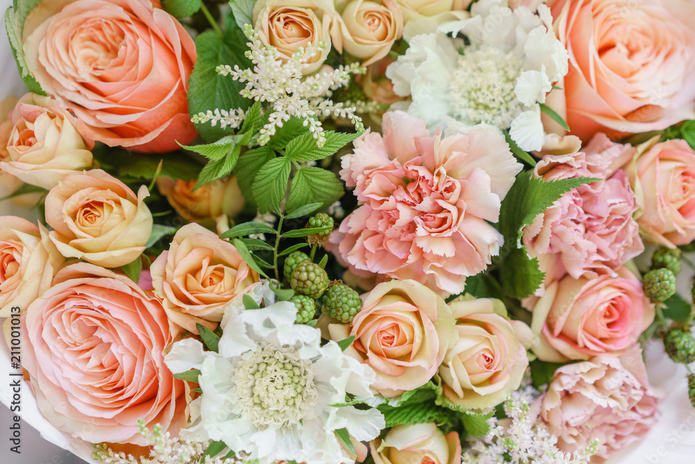 Work florist. Beautiful spring bouquet. Arrangement with mix flowers. The concept of a flower shop, a small family business. Color light peach and orange Work florist. Beautiful spring bouquet. Arrangement with mix flowers. The concept of a flower shop, a small family business. Color light peach and orange