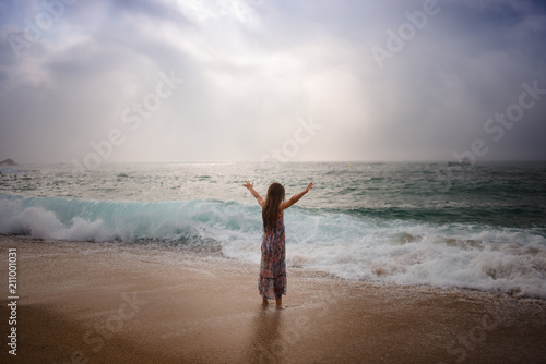 Girl with long hair standing by sea