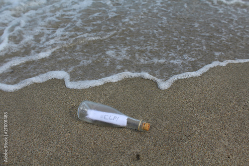 message d'appel au secours dans un bouteille lancée dans la mer