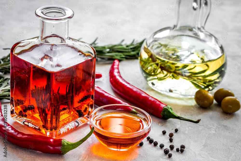 oil in carafe with spices, olives and chili on stone background oil in carafe with spices, olives and chili on stone background