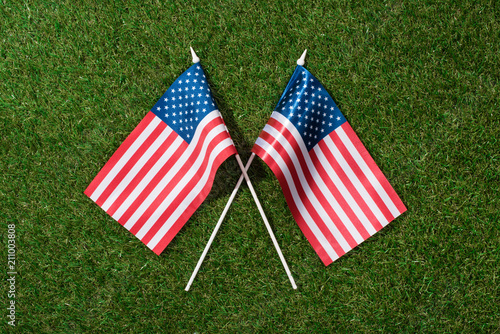 top view of arranged american flagpoles on green grass, 4th july holiday concept