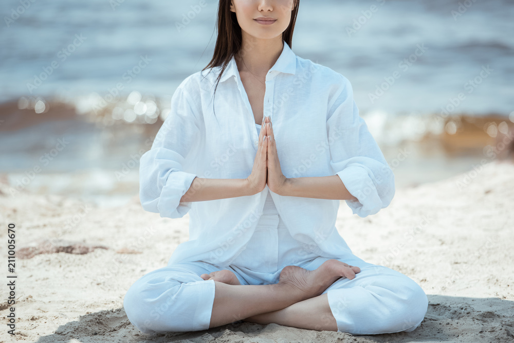 cropped image of woman in anjali mudra (salutation seal) pose on beach ...