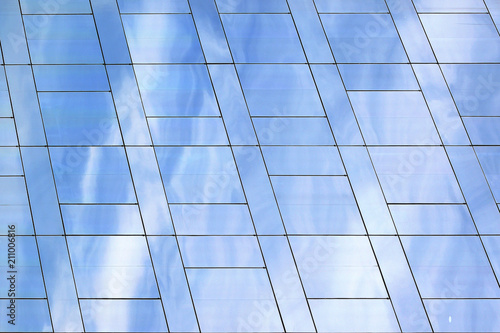 Modern skyscraper glass facade with clouds reflection. Textured background with empty copy space for Editor's text.