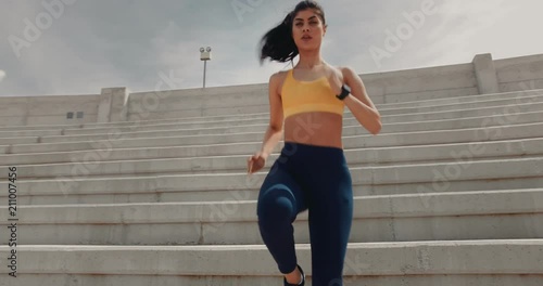 Young athletic woman doing sports training on urban stadium stairs photo