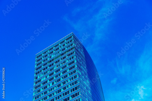 Blue window building against a blue sky with minimal clouds