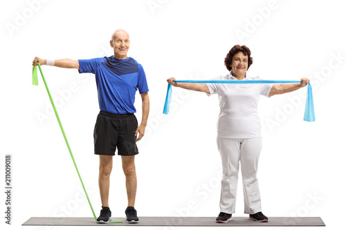 Elderly man and an elderly woman exercising with rubber bands