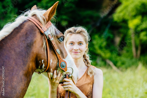 Blond woman with blue eyes with her horse. People and animals friendship concept.