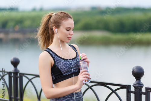 young beautiful girl holding a bottle of cool water for drinking photo