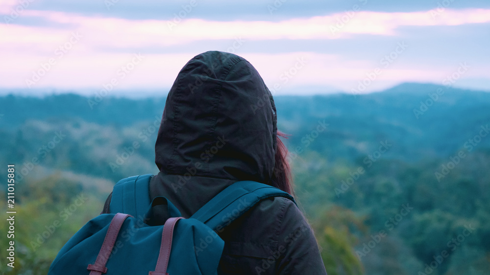 backpack and camping concept from woman in warm cloth with her bag travel and see to forest and mountain in morning after sunrise backpack and camping concept from woman in warm cloth with her bag travel and see to forest and mountain in morning after sunrise