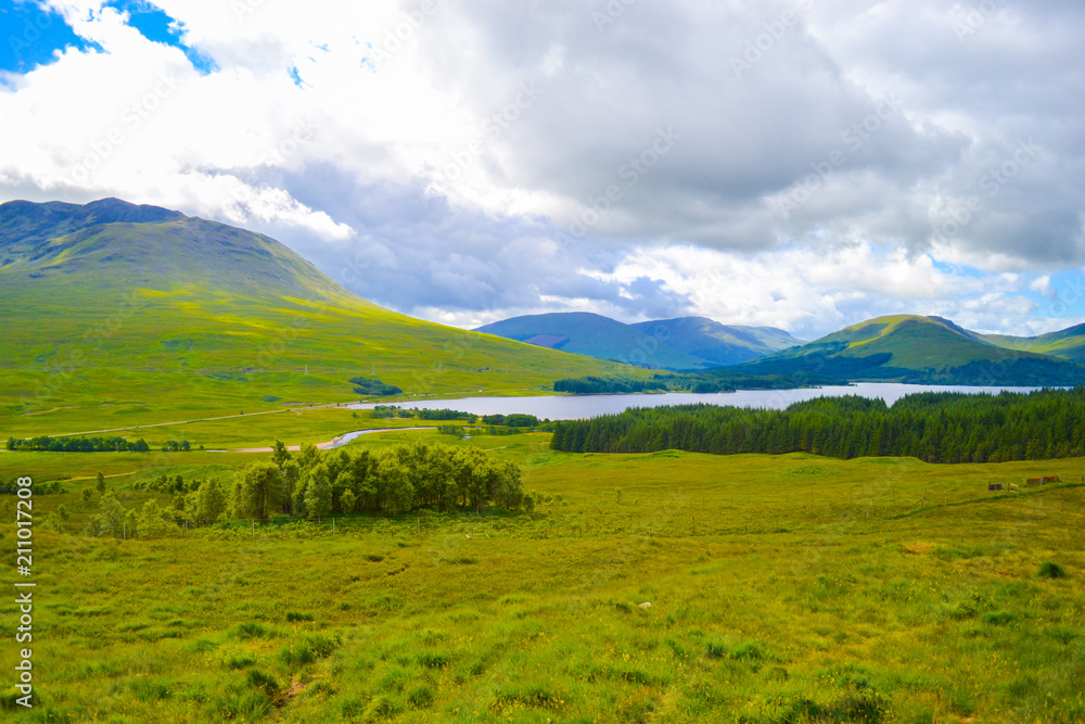 View of Highlands, in Scotland, a beautiful green field with a lake in the center