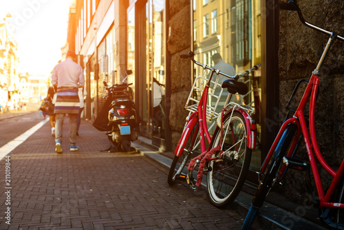 Bicycles parked on the city street in Amsterdam in rays of the s photo