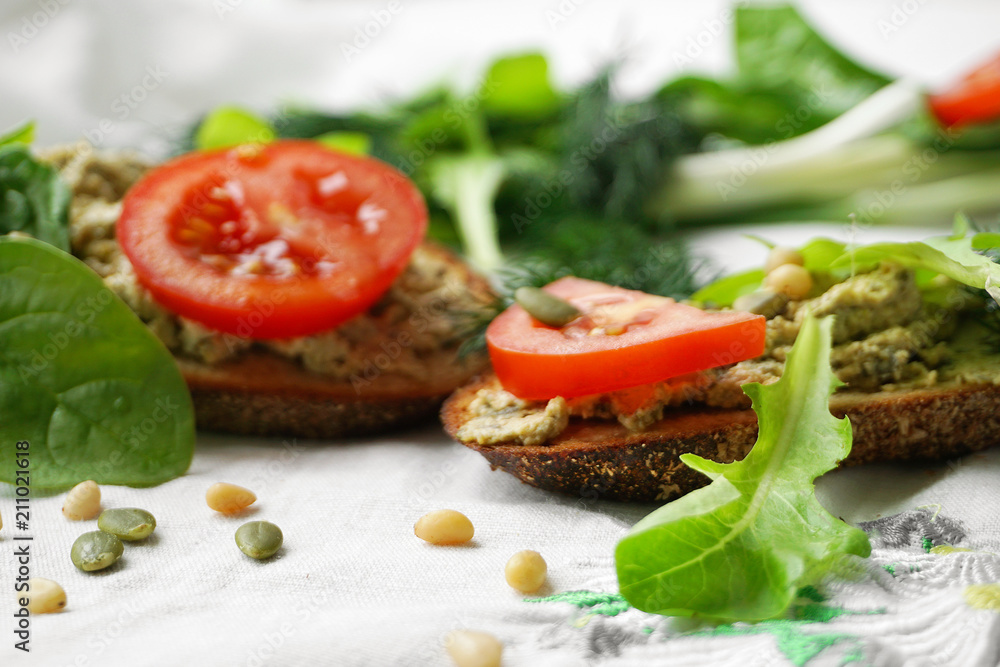 Vegan and vegetarian sandwiches with tofu paste, greens, tomatoes, pine nuts, pumpkin seeds and lettuce. Vegan and vegetarian sandwiches with tofu paste, greens, tomatoes, pine nuts, pumpkin seeds and lettuce.