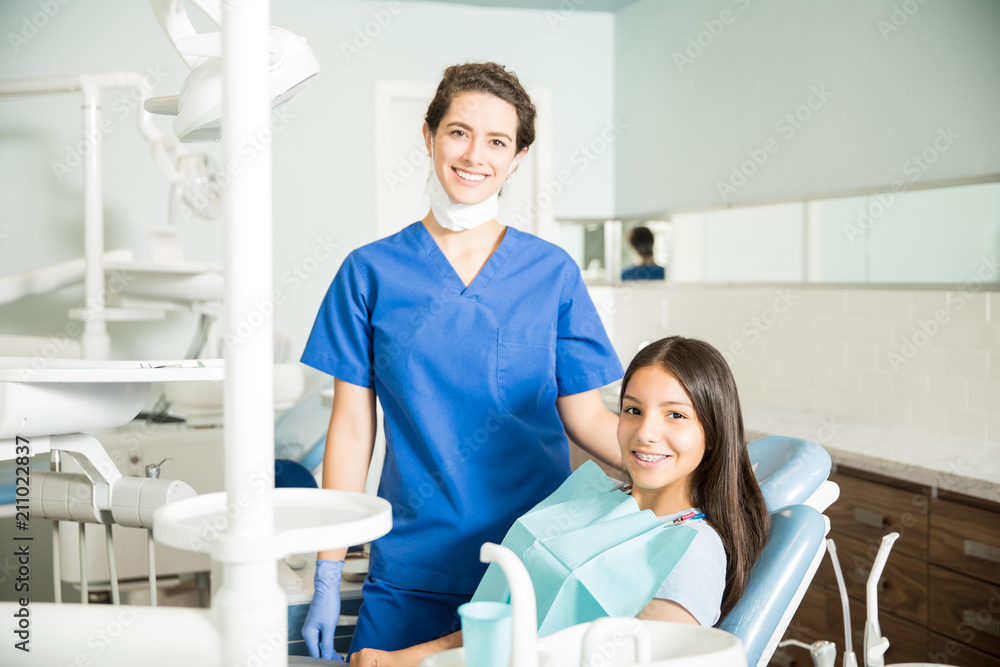 Obraz premium Portrait Of Smiling Dentist And Teenage Girl In Clinic