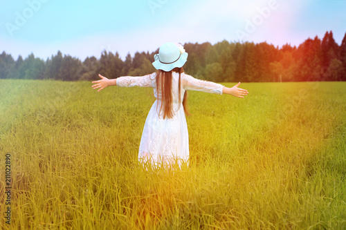 концепция счастья, свободы, жизни и стремления, девочка с длинными волосами гуляет в поле в солнечных лучах