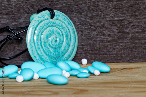 Pile of blue stones with decorative amulet on wooden table, sample for postcard or greeting card photo