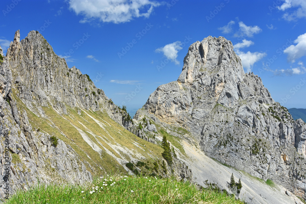 Colorful alpine landscape with rocky mountains, green grass and blue sky in the Ammergau Alps. Bavaria, Germany