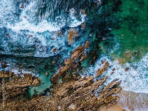 Aerial Drone View Of Dramatic Ocean Waves Crushing On Rocky Landscape