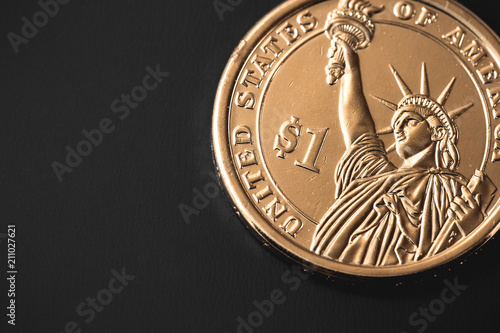 golden one dollar coin isolated on black background © prima91