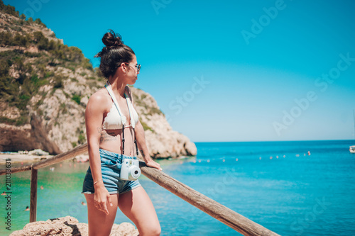 Pretty young girl doing photographs on the beach