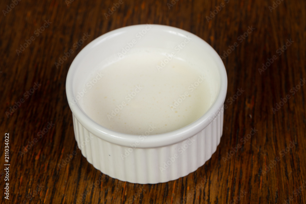 Cream-sour sauce over wooden Cream-sour sauce over wooden