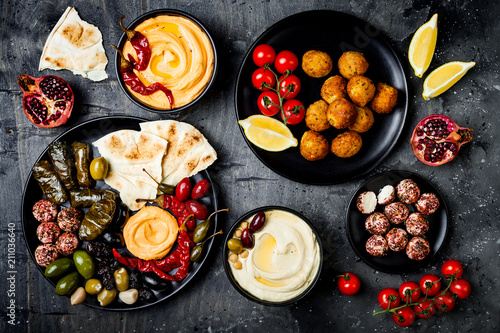 Arabic traditional cuisine. Middle Eastern meze platter with pita, olives, hummus, stuffed dolma, labneh cheese balls in spices. Mediterranean appetizer party idea