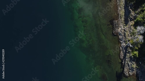 Aerial drone scene of alumine lake and island top view, overhead. Villa Pehuenia, Moquehue, Neuquen Patagonia Argentina. Green and blue colors in the bottom of the lake. photo