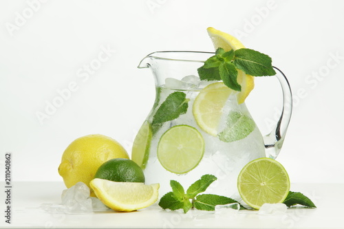 Ice lemonade with lemon, lime and mint on white background