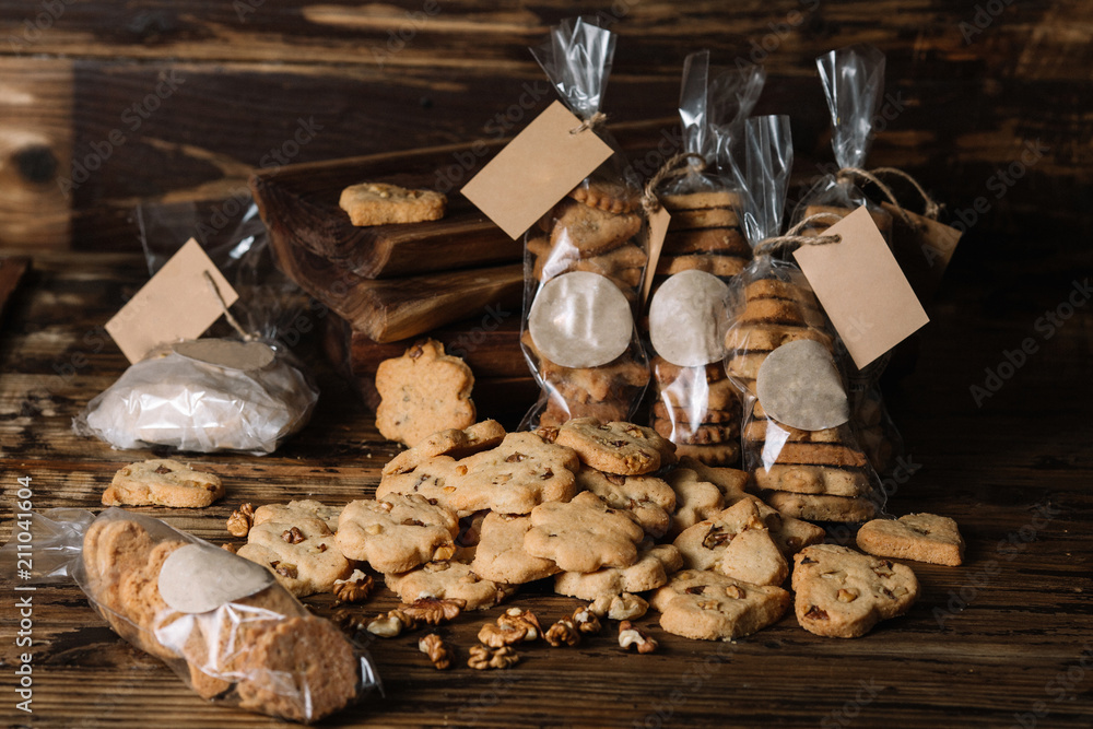 Obraz Packs of homemade biscuits and scattered biscuits on wood background
