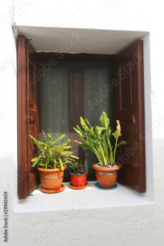 Pots with flowers on the window, on the streets of Lindos, Rhodes, Greece