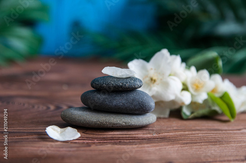 Pyramids of gray zen stones with beautiful fresh white flowers. Concept of harmony  balance and meditation  spa  massage  relax