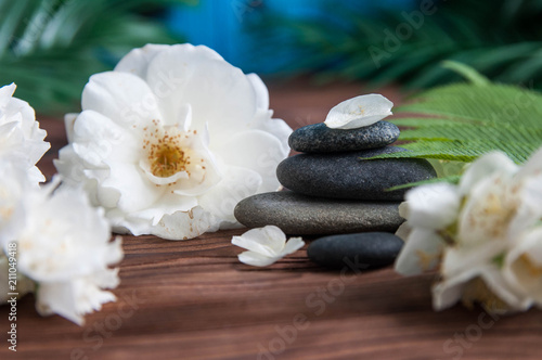 Pyramids of gray zen stones with beautiful fresh white flowers. Concept of harmony  balance and meditation  spa  massage  relax