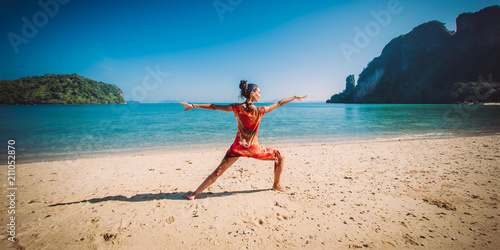Fit woman relaxing and practicing yoga outdoors by the sea