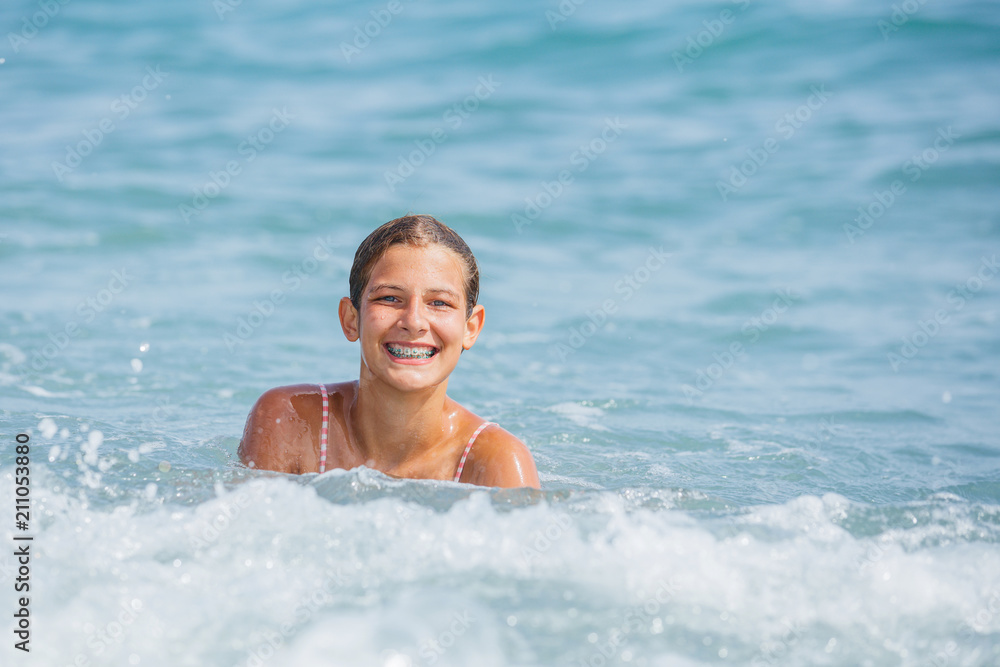 Girl in swimsuit having fun on tropical beach