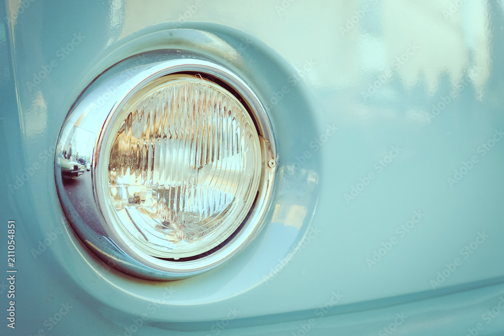old blue car headlight close-up.