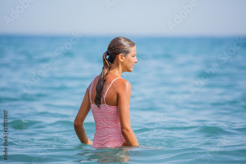 Girl in swimsuit having fun on tropical beach photo