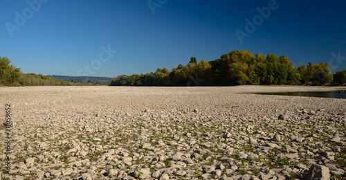 Billede på lærred Dry riverbed on a nice autumn day with visible trees