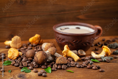Concept of trend modern food industry. Mushroom coffee from mushrooms Chaga, a ceramic cup on a wooden background with coffee beans. Cappuccino, hipster, latte, instagram. Copy space, selective focus.