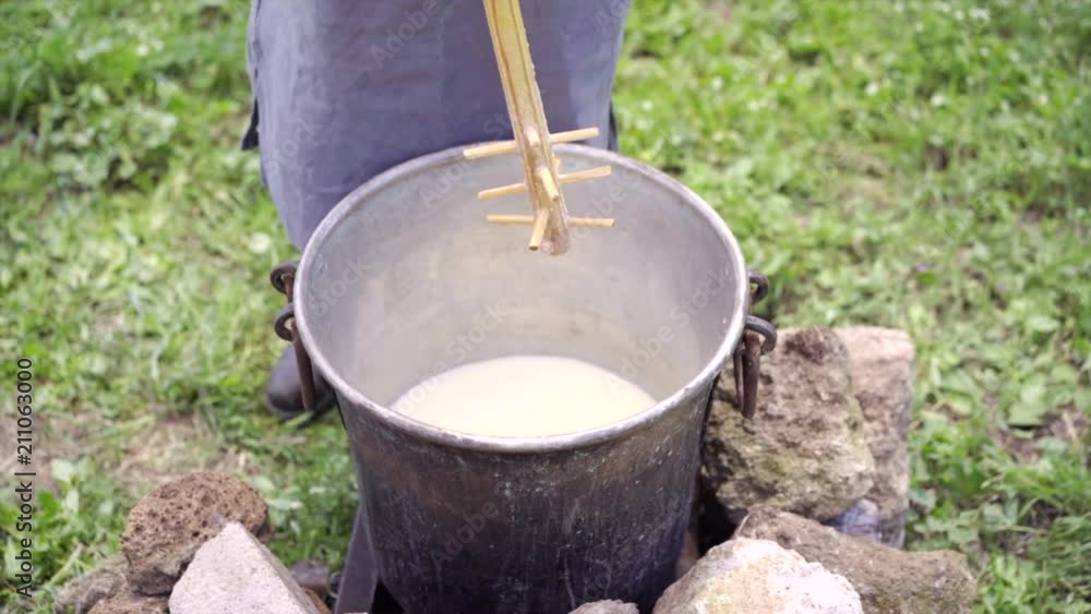 Making cheese from sheep's milk manually ancient traditions mountains. Farmer batters hot fermented sheep's milk. Making cheese from sheep's milk manually ancient traditions mountains. Farmer batters hot fermented sheep's milk.