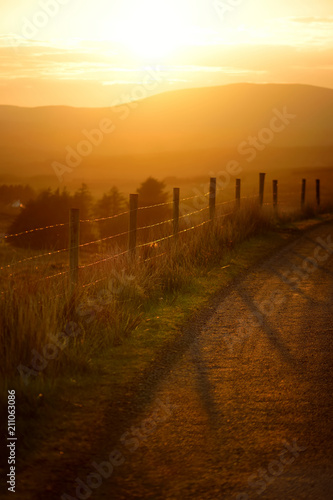 Beautiful sunset in Connemara. Scenic countryside road leading towards magnificent mountains  County Galway  Ireland.